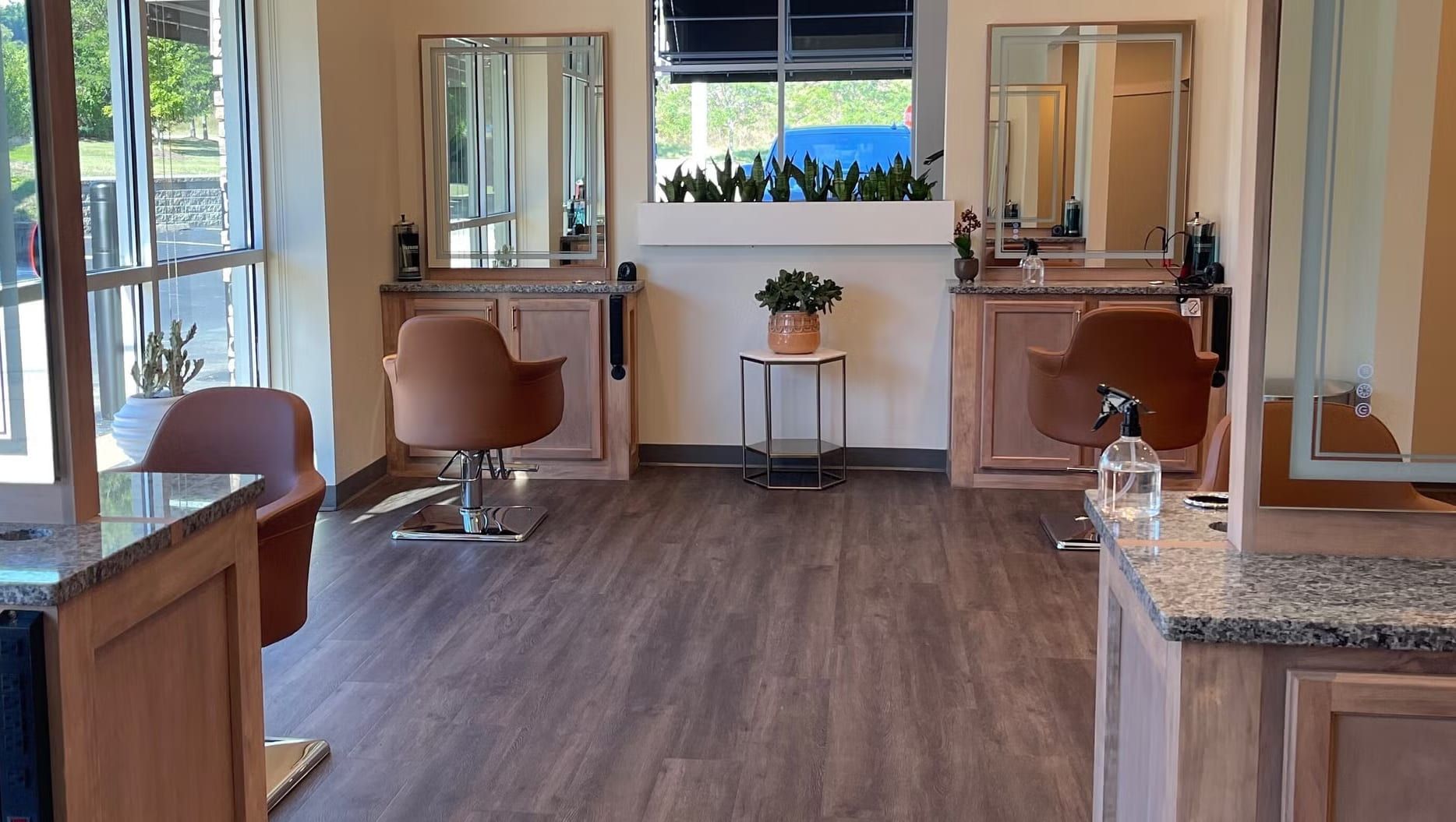 The styling floor at Alora Salon & Wellness Spa in Robinson Township, Pittsburgh, with warm wood, mirrors and plants