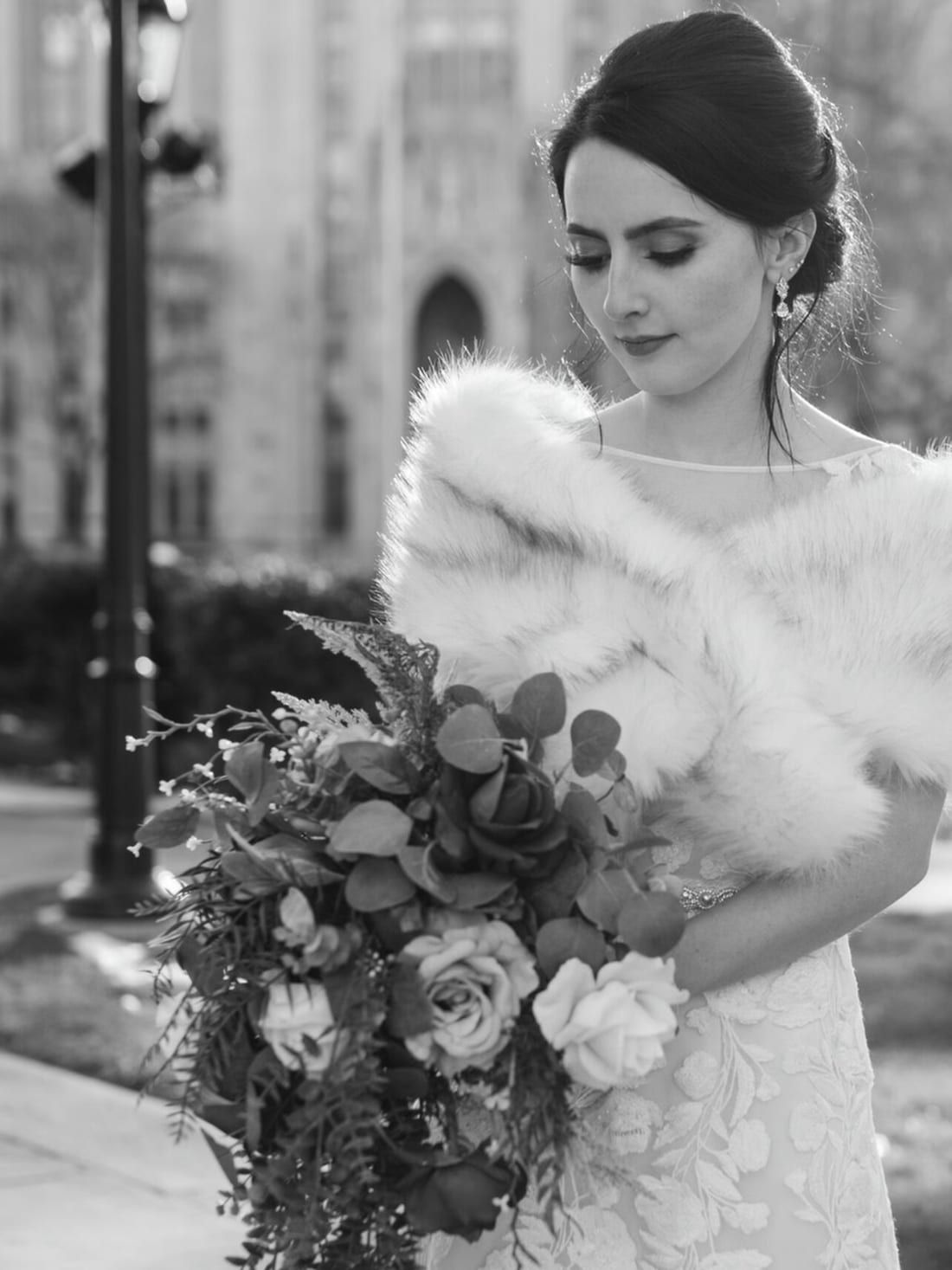 A bride with a smooth low updo and a winter bouquet, styled at Alora Salon in Pittsburgh